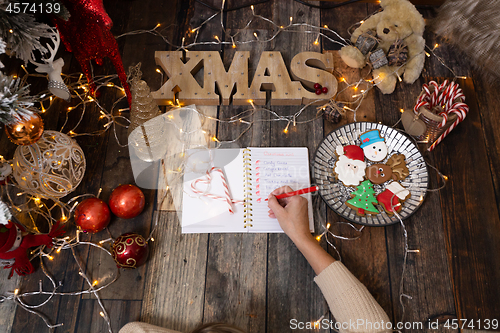 Image of Writing a Christmas list among Christmas decorations and gingerb