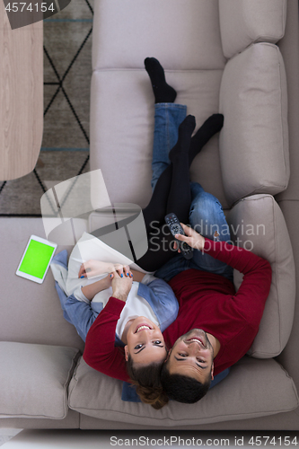 Image of Young couple on the sofa watching television top view