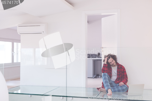 Image of young freelancer in bathrobe working from home