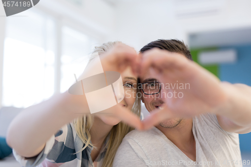 Image of couple making heart with hands