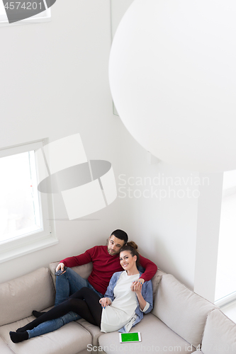 Image of Young couple on the sofa watching television