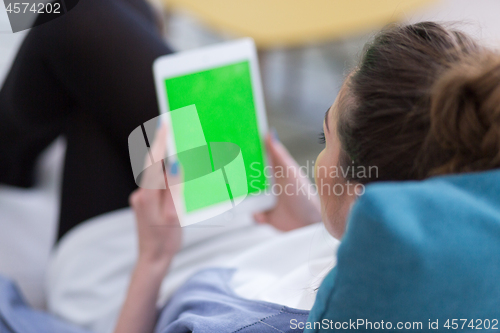 Image of woman on sofa using tablet computer