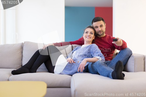 Image of Young couple on the sofa watching television