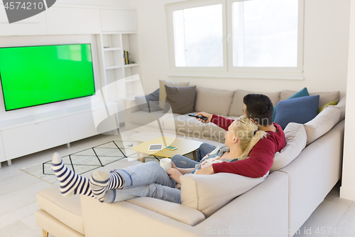 Image of Young couple on the sofa watching television