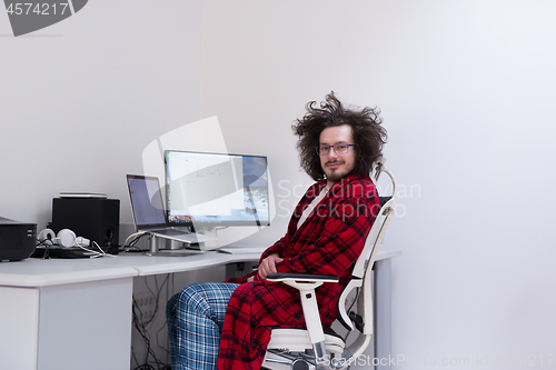 Image of graphic designer in bathrobe working at home