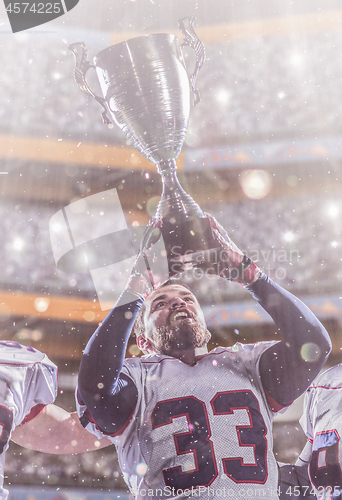 Image of american football player with trophy celebrating victory in the 