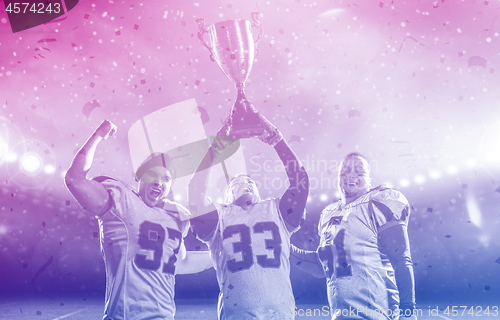 Image of american football team with trophy celebrating victory in the cu