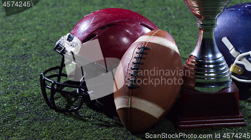 Image of closeup of american football,helmets and trophy