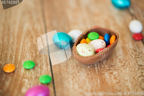 Image of chocolate easter egg and candy drops on table