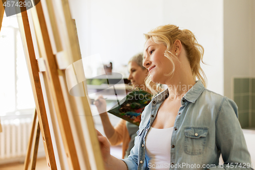 Image of woman with easel drawing at art school studio