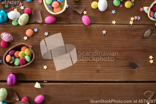 Image of chocolate eggs and candy drops on wooden table