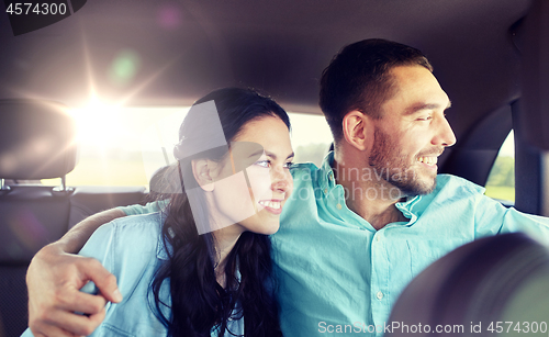 Image of happy man and woman hugging on taxi back seat