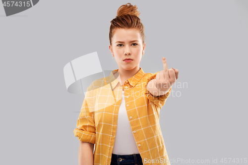 Image of red haired teenage girl showing middle finger