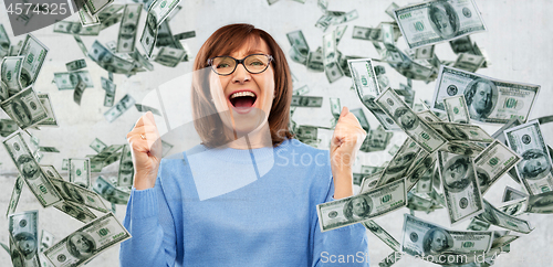 Image of happy senior woman celebrating success over money