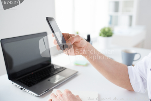 Image of close up of businessman using smartphone at office