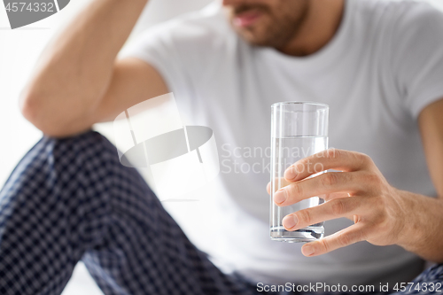 Image of close up of sick man with glass of water