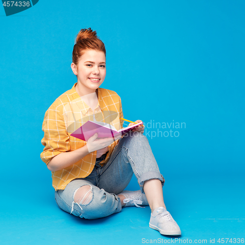 Image of happy teenage student girl with diary or notebook