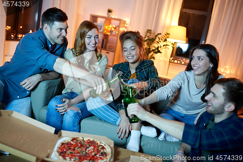 Image of happy friends with drinks and pizza party at home