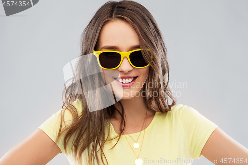 Image of teenage girl in yellow sunglasses and t-shirt