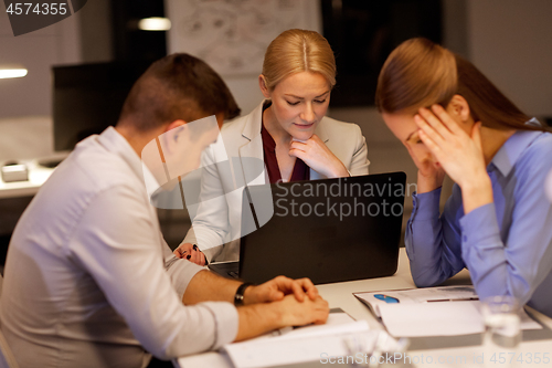 Image of business team with laptop working at night office