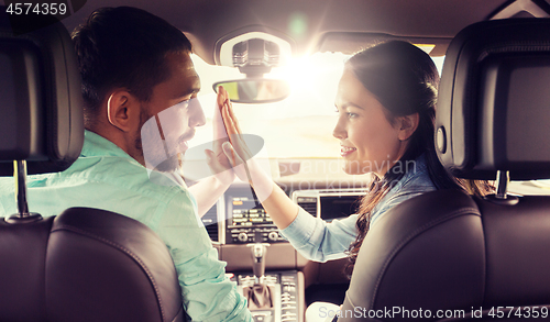 Image of happy man and woman driving in car