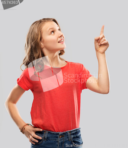 Image of smiling teenage girl pointing finger to something
