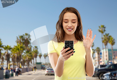 Image of smiling teenage girl having video call smartphone