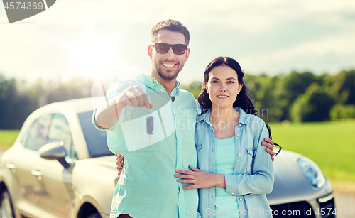 Image of happy man and woman with car key hugging