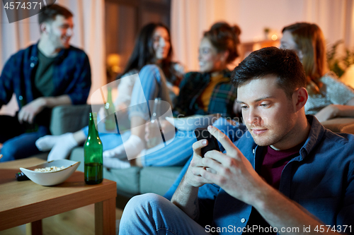 Image of man with smartphone at home party