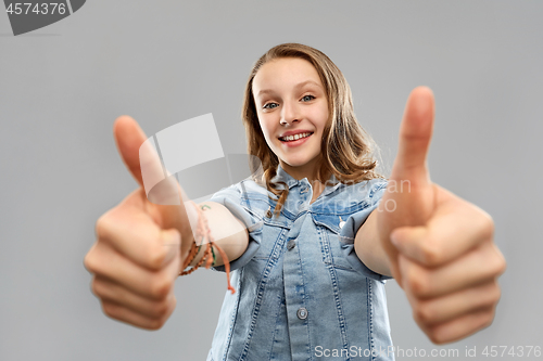 Image of smiling teenage girl showing thumbs up