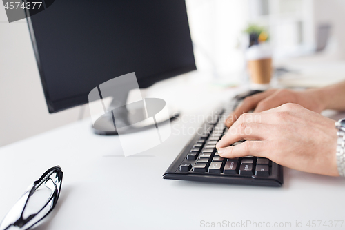 Image of close up of male hands typing on computer keyboard