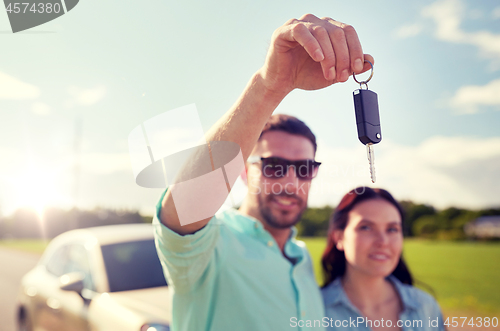 Image of happy man and woman with car key outdoors