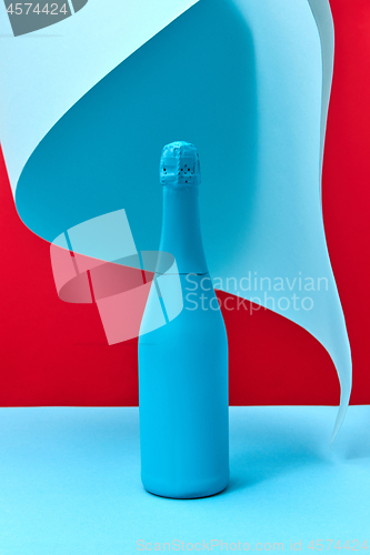 Image of Mock up blue painted wine bottle with folded paper.