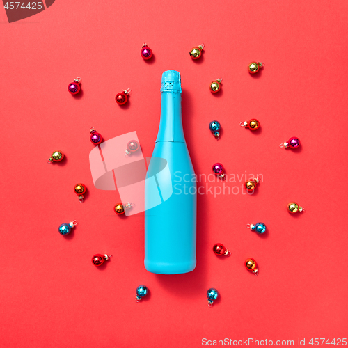 Image of Blue painted mock up bottle on a background covered Christmas balls.