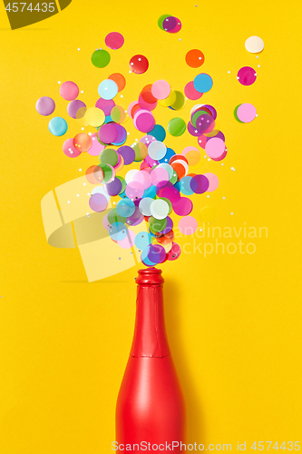 Image of Colorful confetti as a bubble foam from painted red wine bottle.