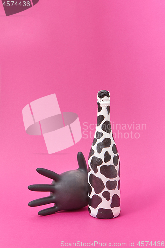 Image of Latex glove balloon with painted white bottle with black spots.