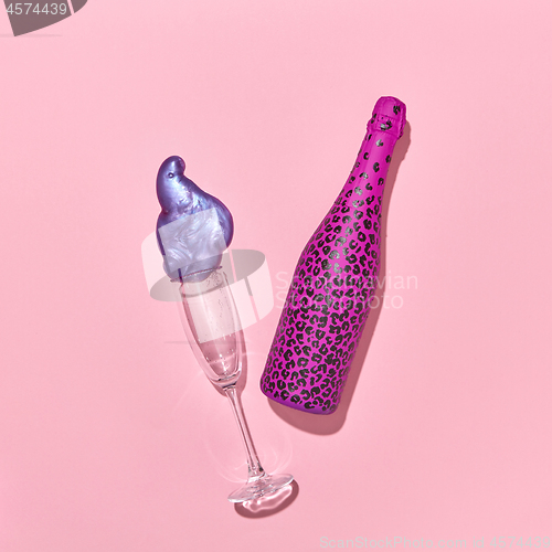 Image of Decorative painted bottle with glass and paint spot on a pink.