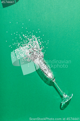 Image of Colorful Christmas tinsel in a glass as a champagne drink bubbles.