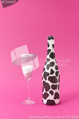 Image of Painted black spots wine bottle with glass of white powder.