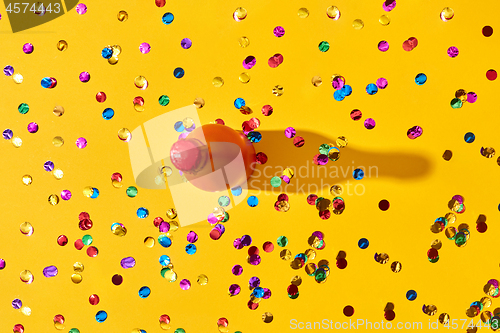 Image of Holiday background with red painted bottle and colored confetti.