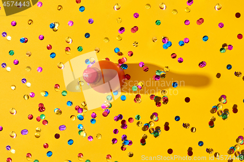 Image of Holiday background with red painted bottle and colored confetti.