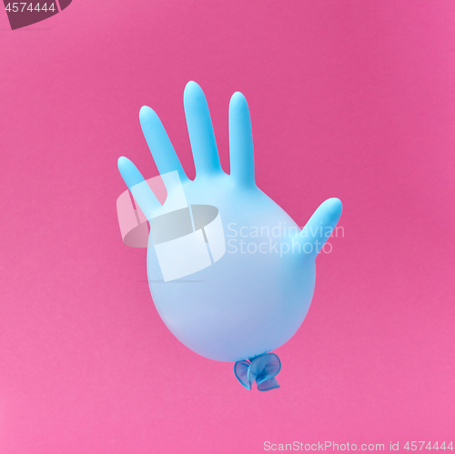 Image of Blue latex glove balloon on a hot pink background.