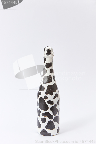 Image of Creative white wine bottle painted with black spots.