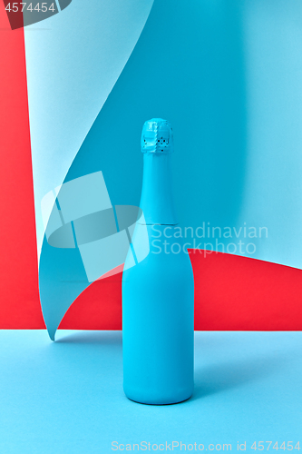 Image of Decorative painted blue wine bottle mock up on a duotone wavy background.