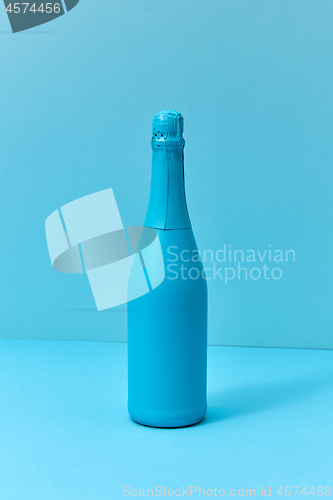 Image of Holiday champagne mock up bottle painted blue with soft shadows.