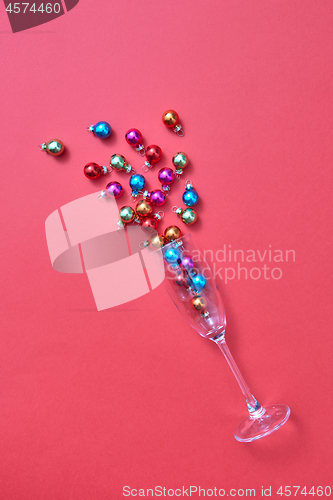 Image of Colorful Christmas balls in a glass as a champagne drink bubbles.