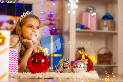 Image of Beautiful ten-year-old girl lies on a rug in the New Year\'s interior