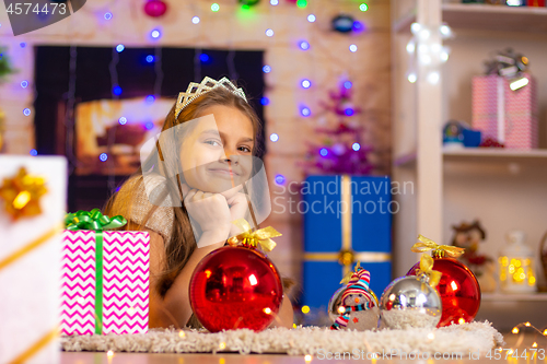 Image of Beautiful ten-year-old girl lies on a rug in the New Year\'s interior and looks at the frame cheerfully