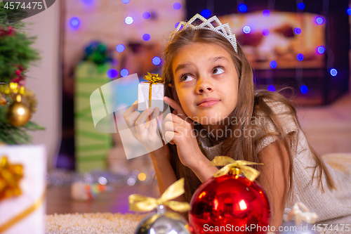 Image of Girl holding a small pretty gift in her hands