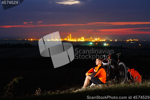 Image of guy has a rest sitting near his bike